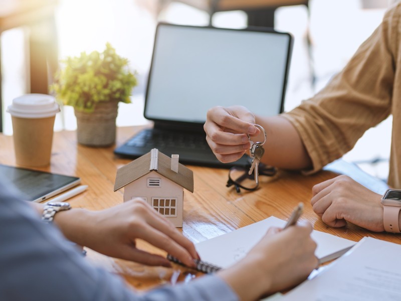 Home and real estate trading business. Real estate agent giving keys to house woman owner.